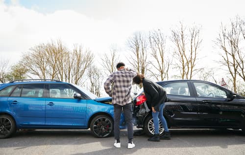 people reviewing car damage after accident